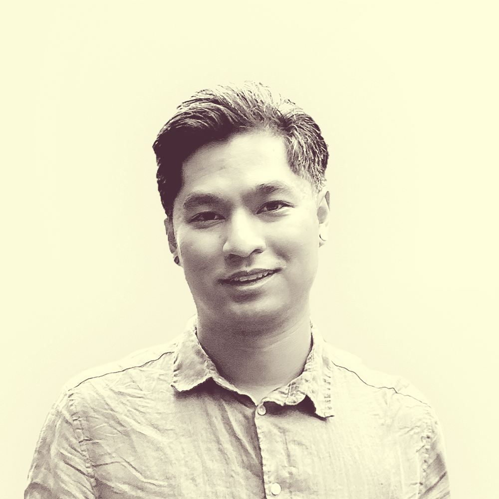 A Cambodian American male with short black combed hair wearing a red collar shirt.